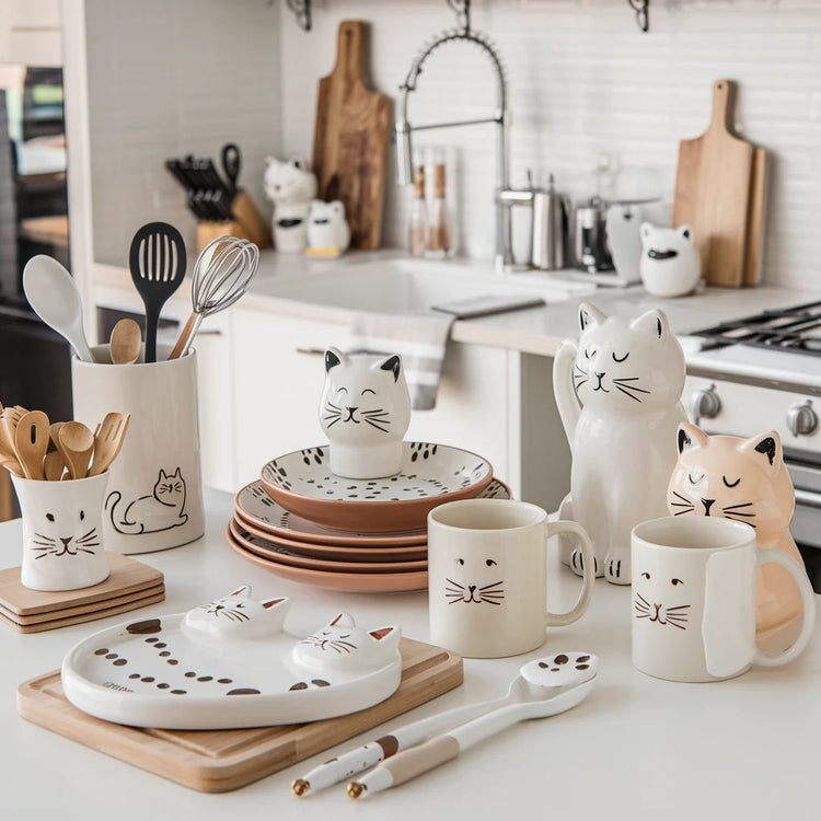 Cat lover gift collection for the kitchen with cat-themed mugs, dishware, and accessories. Includes cat-shaped salt and pepper shakers, cutting boards, and other charming kitchen essentials for cat lovers